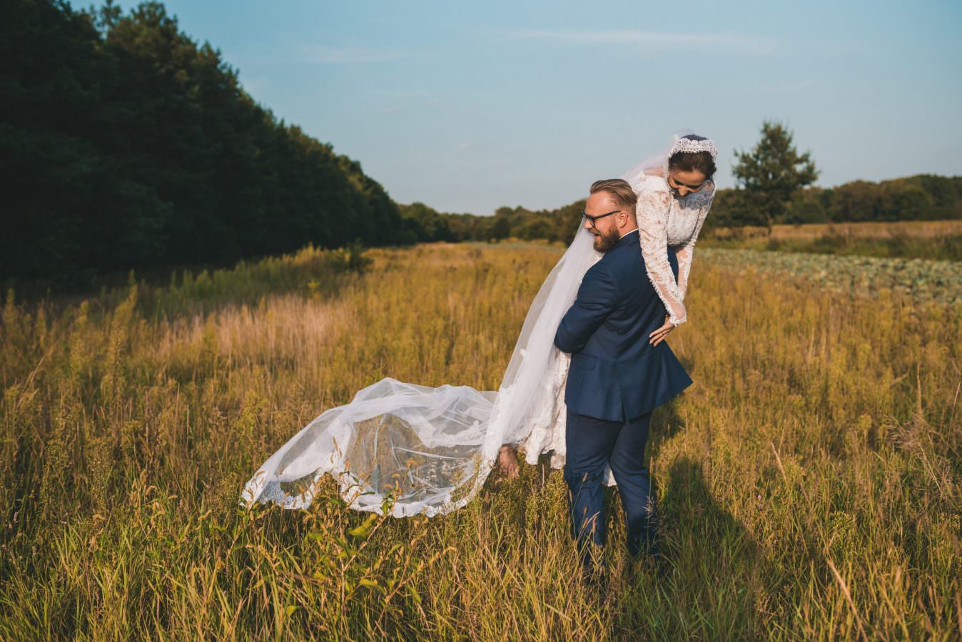 groom lift his wife on field