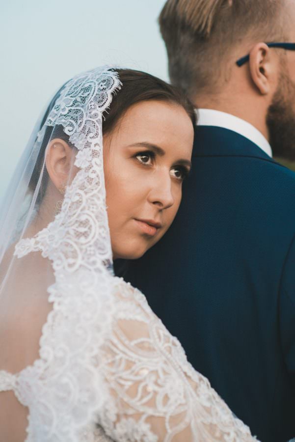 groom in white dress portrait face on the back of the groom