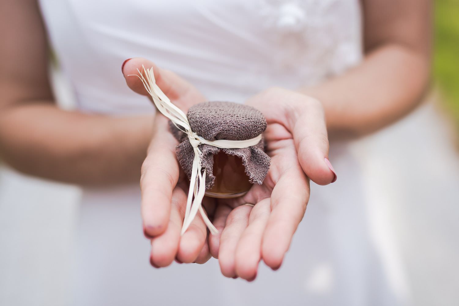 jar of honey on bride hands