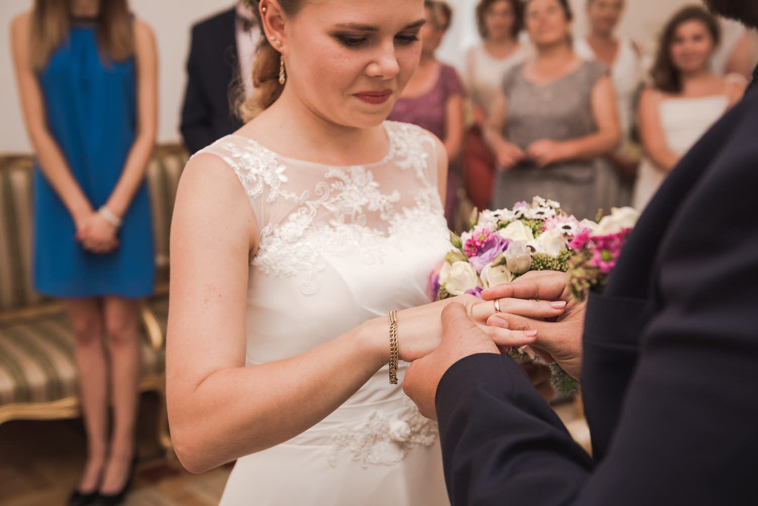 groom puts a wedding ring on his wife