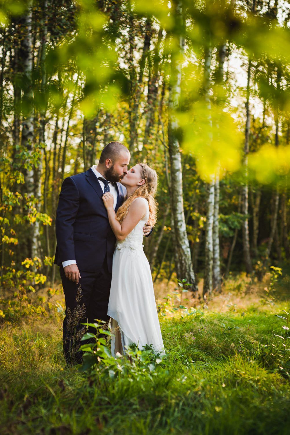married couple kissing under the treee