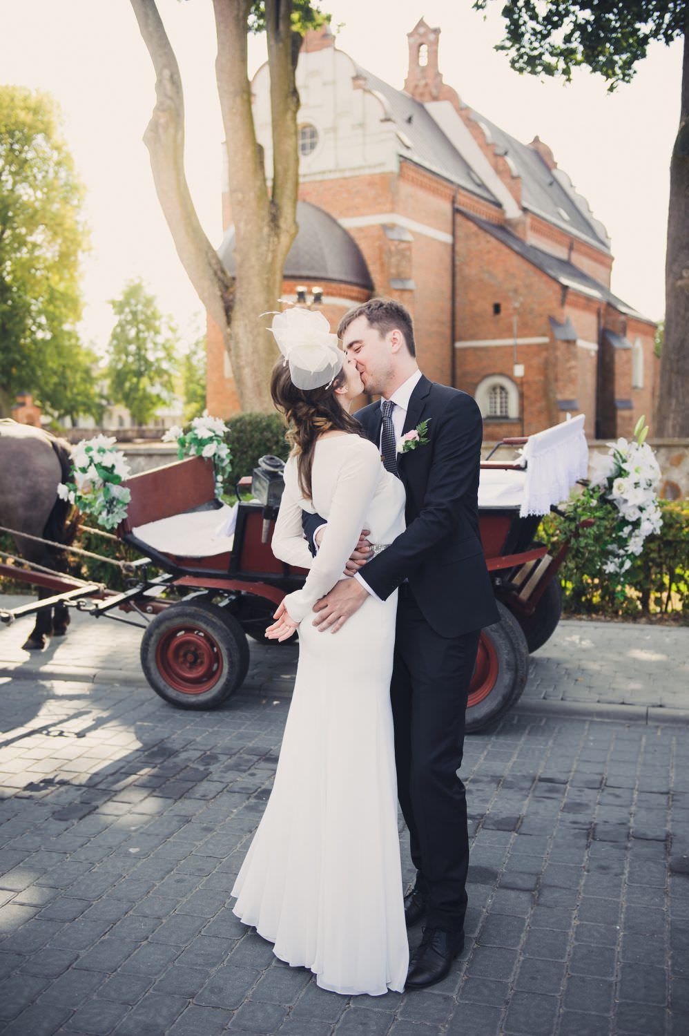 bride and groom kissing in the sun brok town Poland