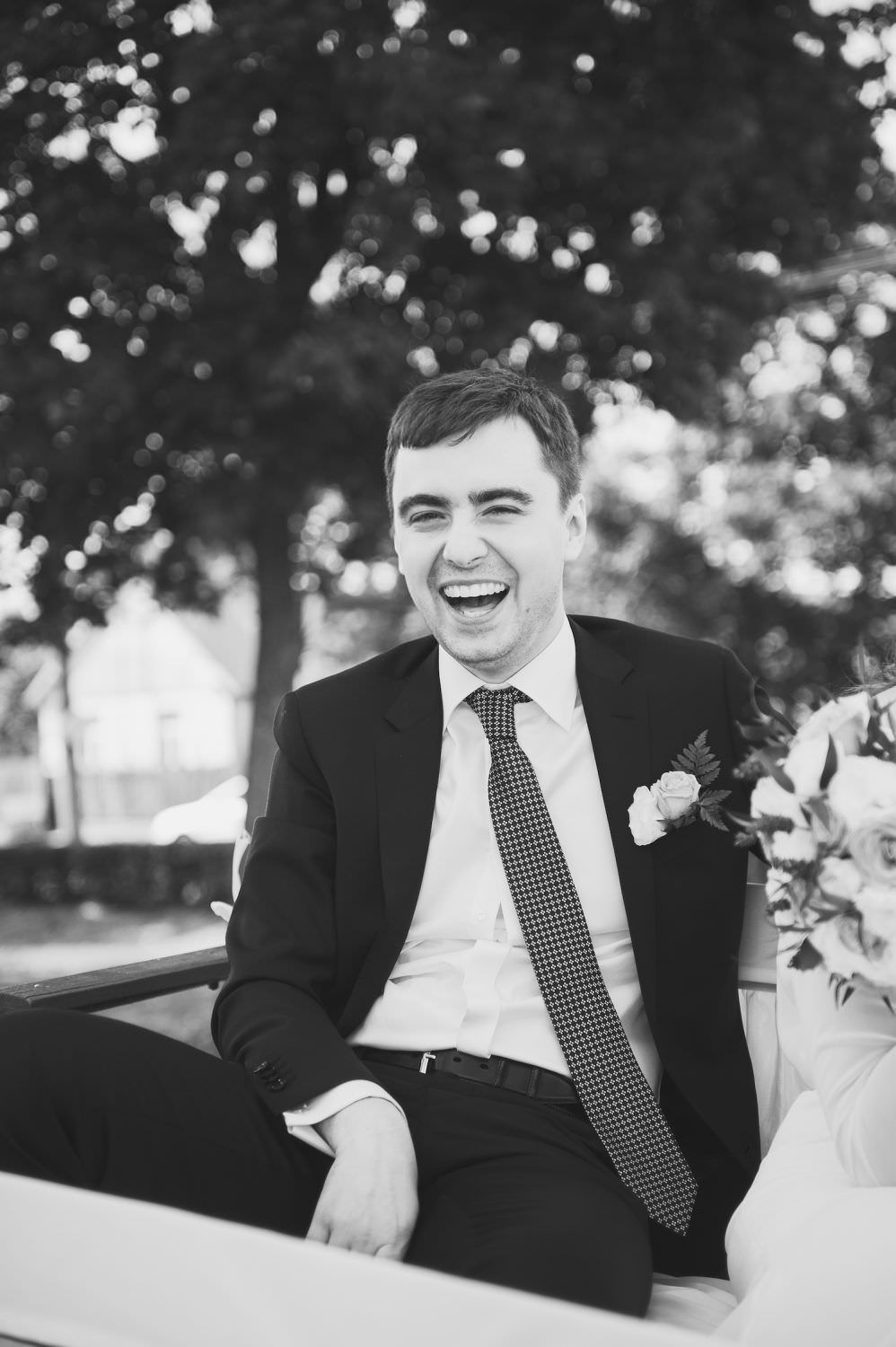 black and white groom laughs smile tie white shirt