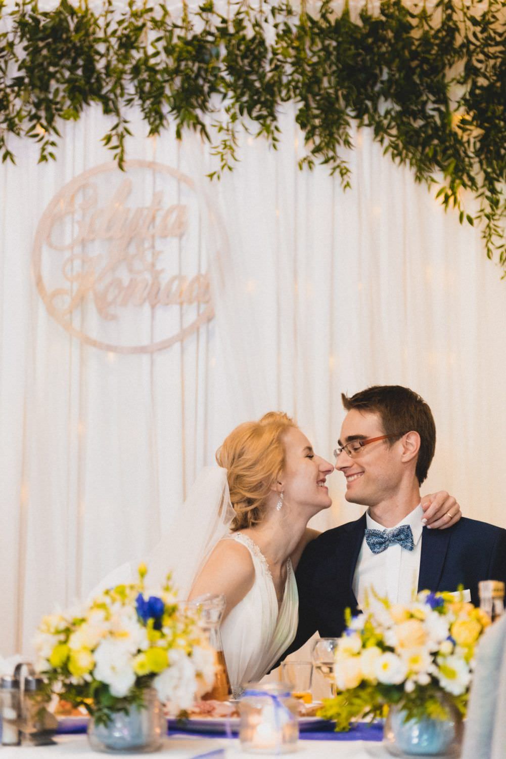 bride and groom at wedding table laugh to each other