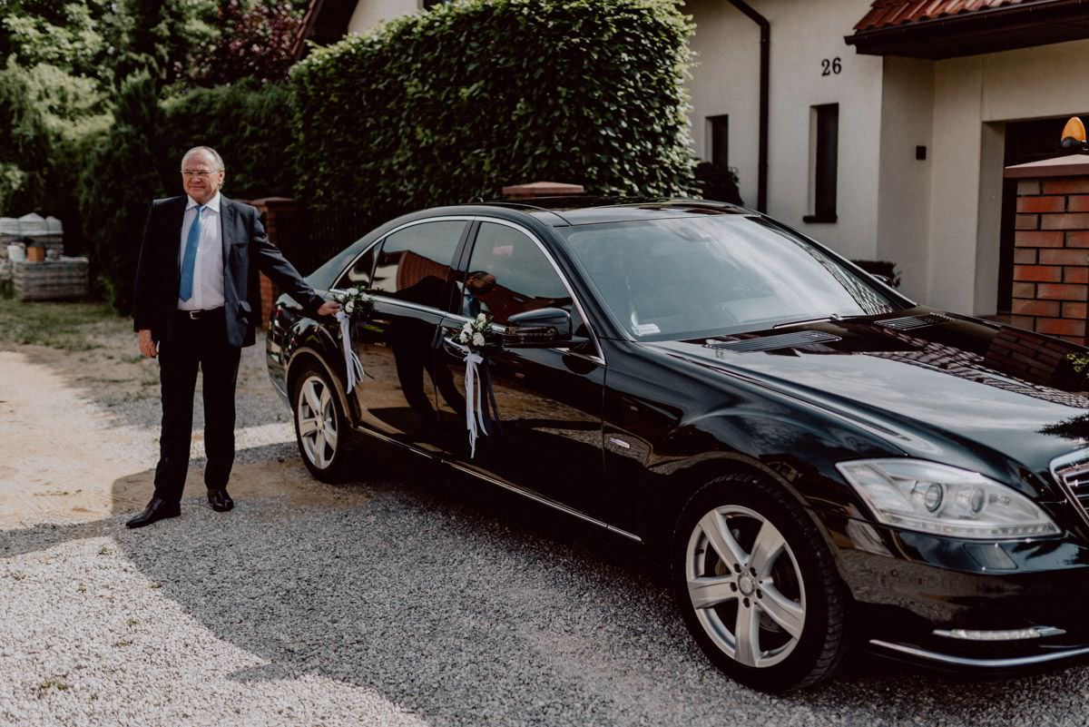 mercedes benz driver waiting for the bride next to the car touching car handle