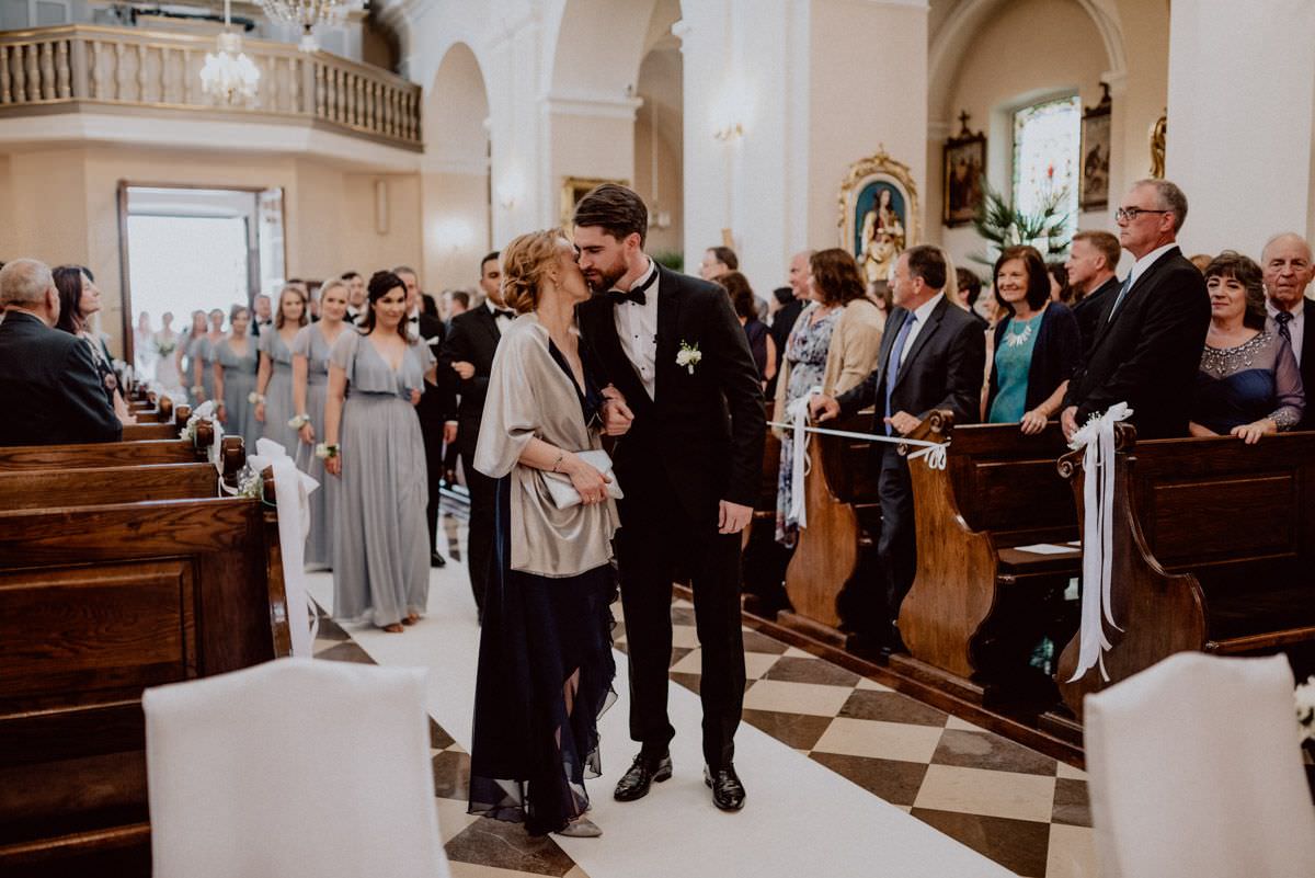 mother kiss his son in front of the altar
