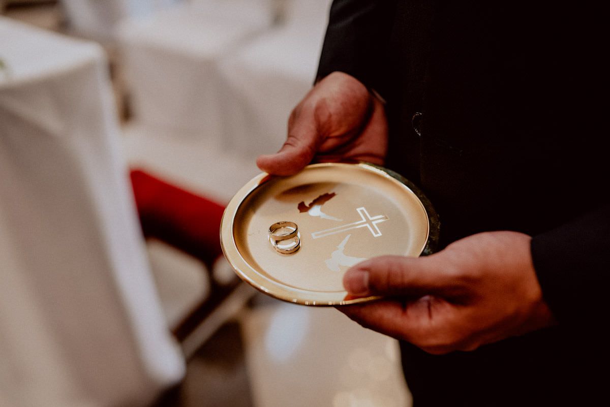 wedding rings on gold plate holds by the groomsman