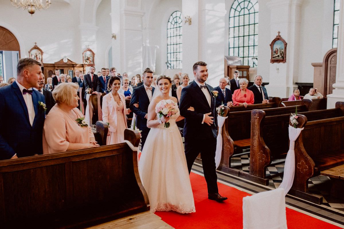 bride and groom goes into the church and smiling