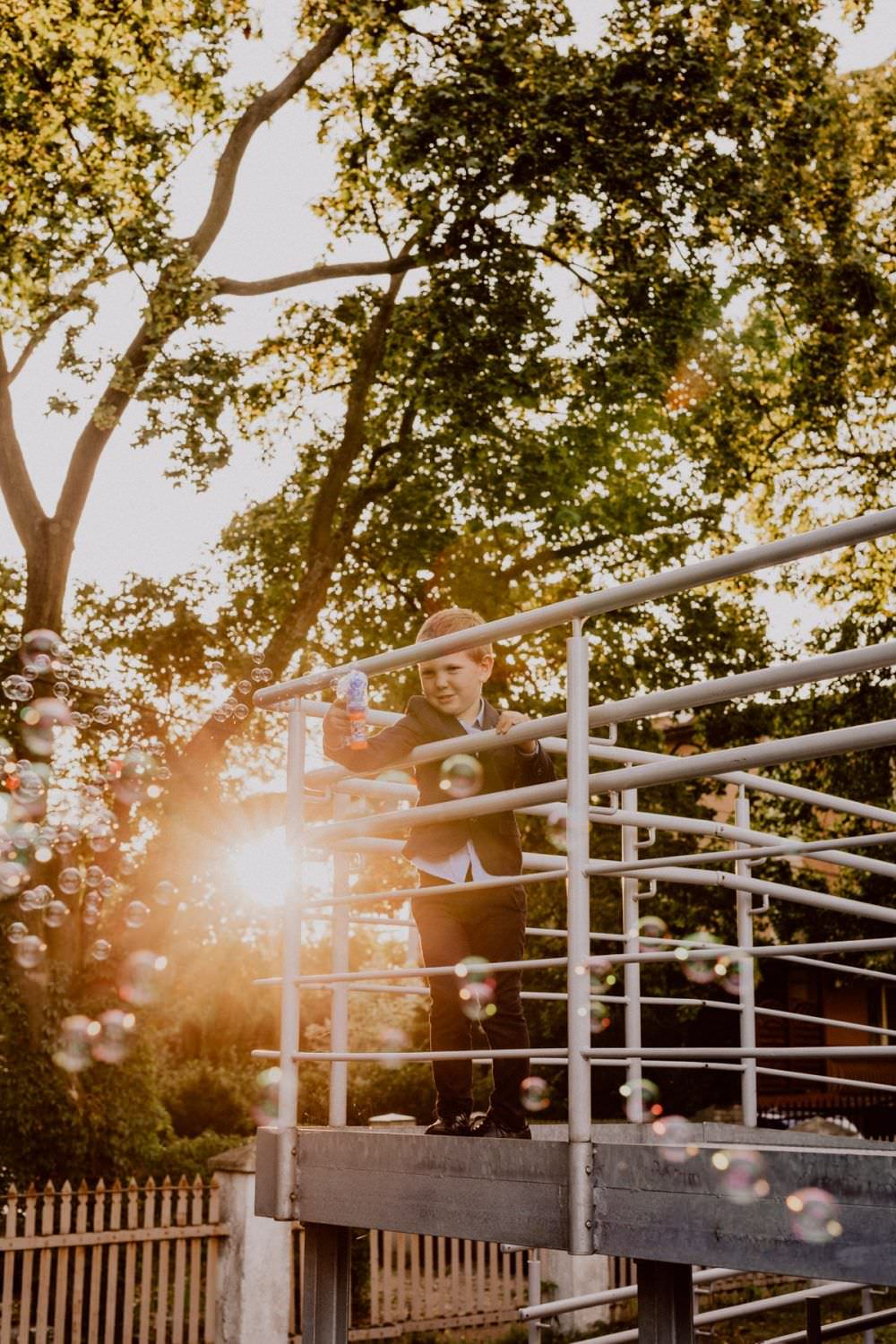 the child is blowing bubbles at sunset