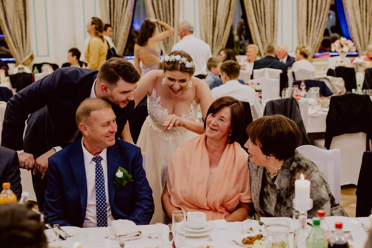 bride and groom with parents at the table on wedding party