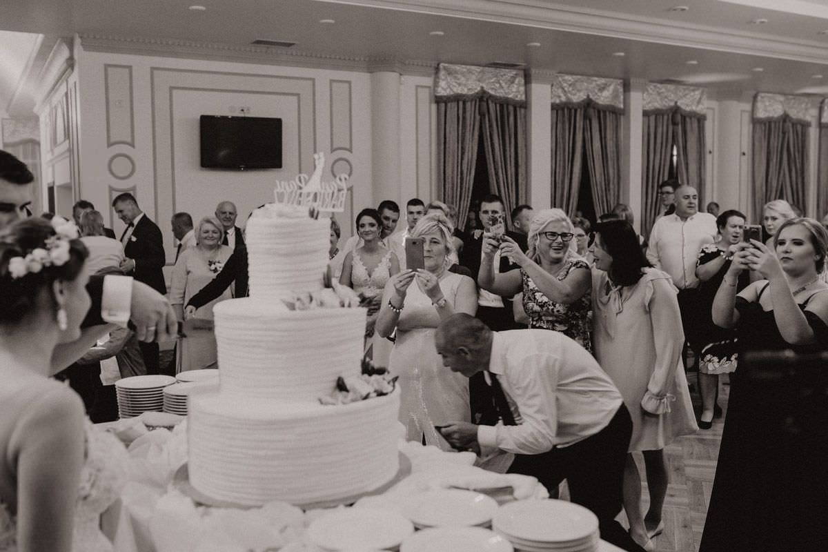 wedding guests with smartphones taking a photo of wedding cake
