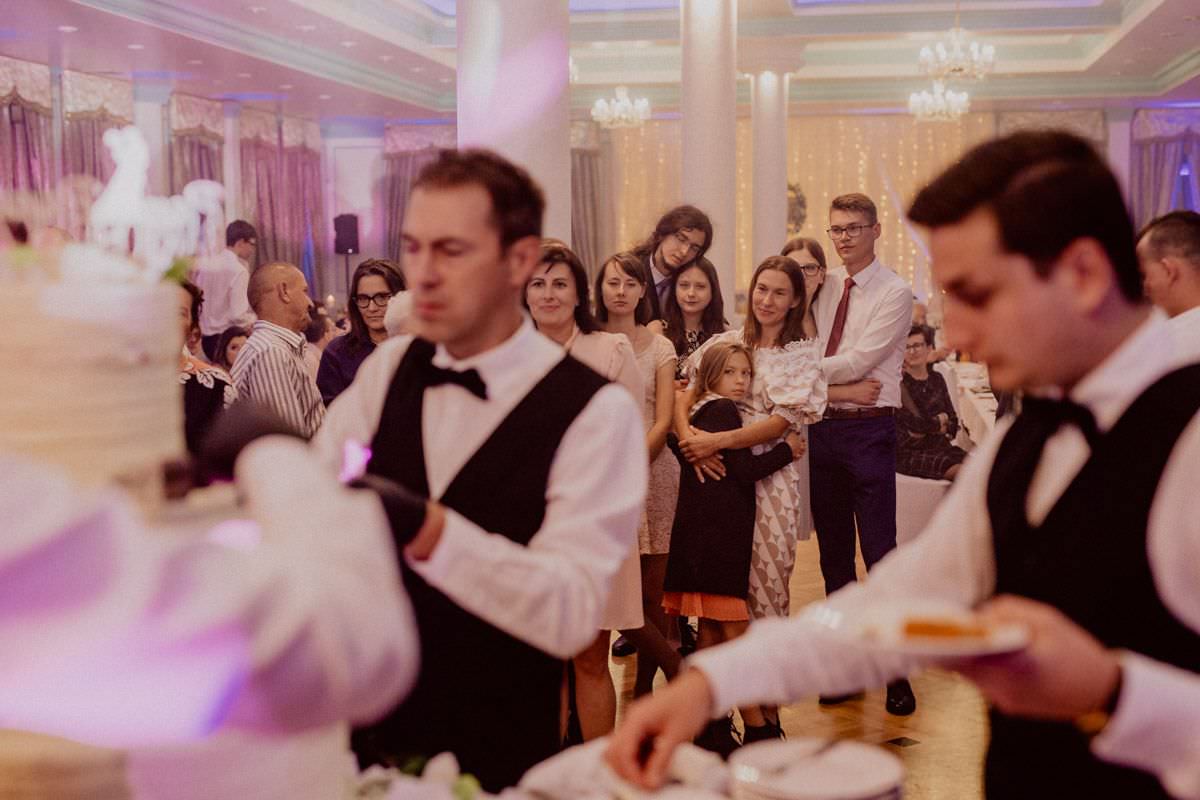 the guests are looking on cutting the wedding cake