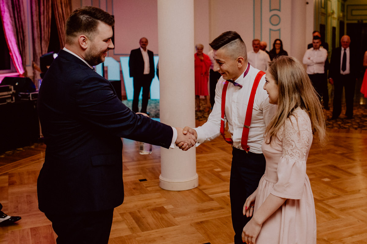 the groom and the wedding guest shake hands